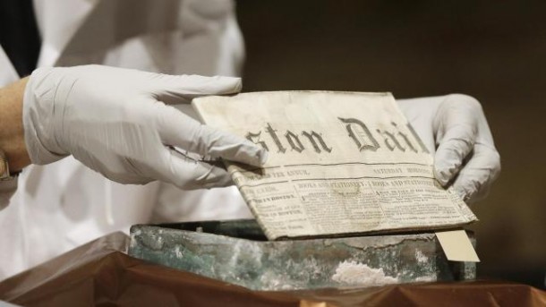 Museum of Fine Arts Boston Head of Objects Conservation Pam Hatchfield removes a folded 19th century newspaper from a time capsule at the museum, Tuesday, Jan. 6, 2015, in Boston. The original capsule was made of cowhide and believed to have been embedded in a cornerstone when construction on the state Capitol building began in 1795. The contents were shifted to a metal box in 1855 which was unearthed last month at the Statehouse.
