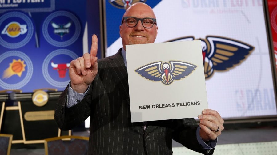New Orleans Pelicans representative holds up one finger after receiving the first pick in the draft.