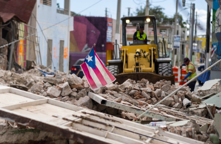 A Puerto Rican flag waves on top of a pile of rubble as debris is removed from a main road in Guánica. Ricardo Arduengo /AFP via Getty Images