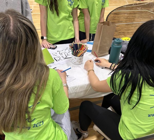Student volunteers Maggie Zheng, Ticianna Panza, and Christina Nikolopoulos organizing the stands. 