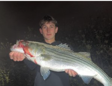 Adrien with recently caught striped bass.